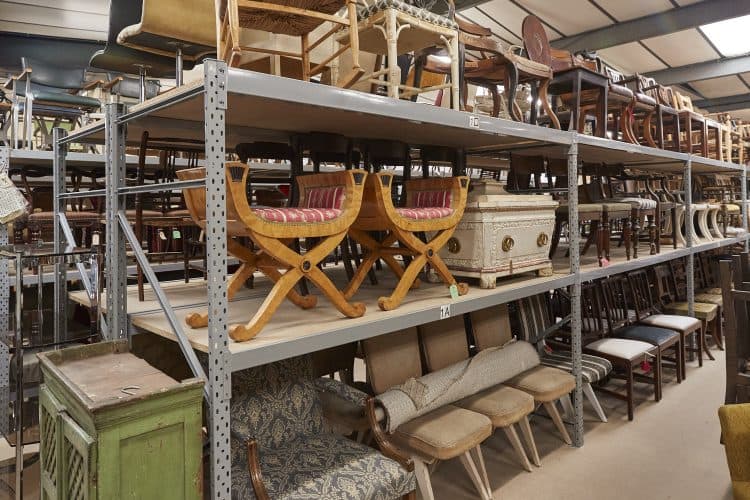 Rescued chairs and furniture stacked on warehouse racking, ready to be re-homed